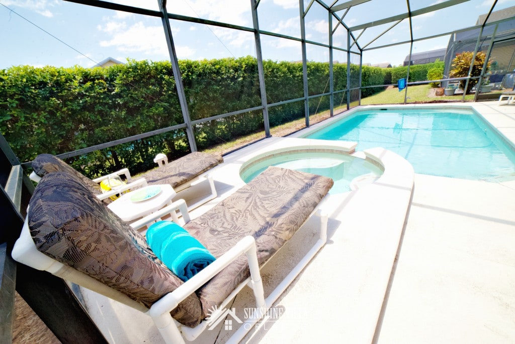 Two large lounge chairs overlooking jacuzzi spa and outdoor private pool at Sunshine Villa at Glenbrook Resort, a short-term vacation rental home in Orlando near Walt Disney World