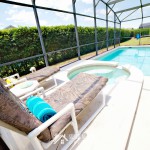 Two large lounge chairs overlooking jacuzzi spa and outdoor private pool at Sunshine Villa at Glenbrook Resort, a short-term vacation rental home in Orlando near Walt Disney World