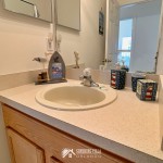 Bathroom near the two twin bedrooms at Sunshine Villa at Glenbrook Resort, a short-term vacation rental home in Orlando near Walt Disney World, close up of the bathroom vanity counter, picture frame with a pelican and lighthouse decor.