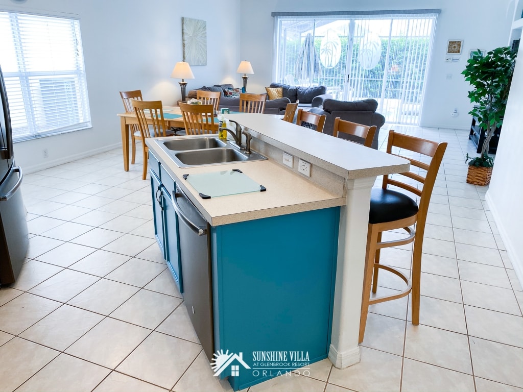 Kitchen Island with Dining Room and Living Room in the background at Sunshine Villa at Glenbrook Resort, a short-term vacation rental home in Orlando near Walt Disney World