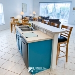 Kitchen Island with Dining Room and Living Room in the background at Sunshine Villa at Glenbrook Resort, a short-term vacation rental home in Orlando near Walt Disney World